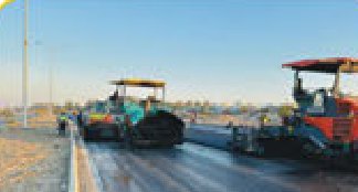 Two asphalt pavers laying a road